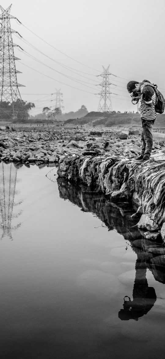 earth地球 首页界面示意，一颗立体地球占据屏幕中央，下方是地形、气候、人文三个图层切换按钮，背景为深色星空，手机竖屏拍摄